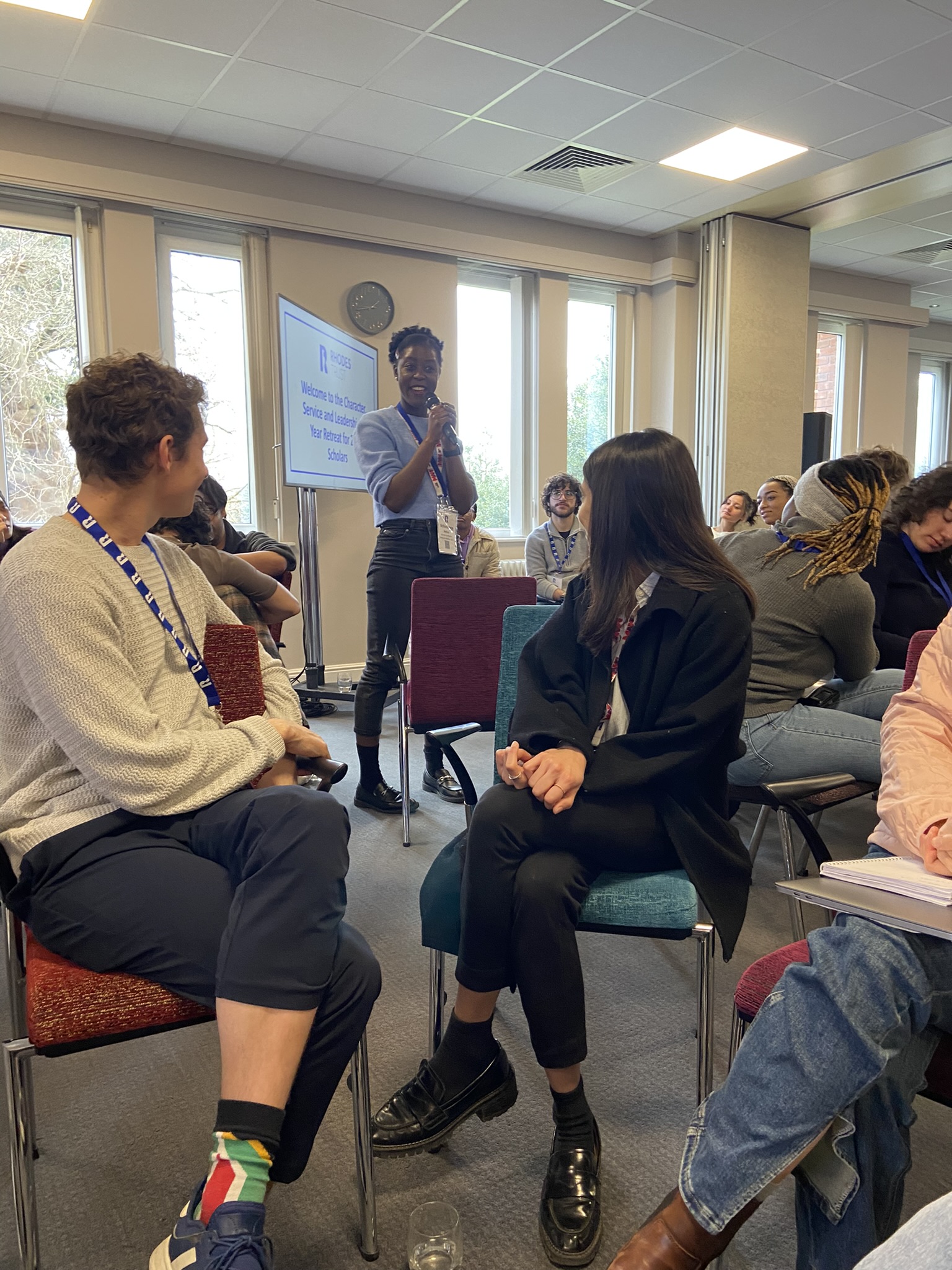 1St Retreat For Class Of 2022 Scholars In The Plenary Room, Turning To Face An Alumni Faciliator Who Is Stood With Microphone,