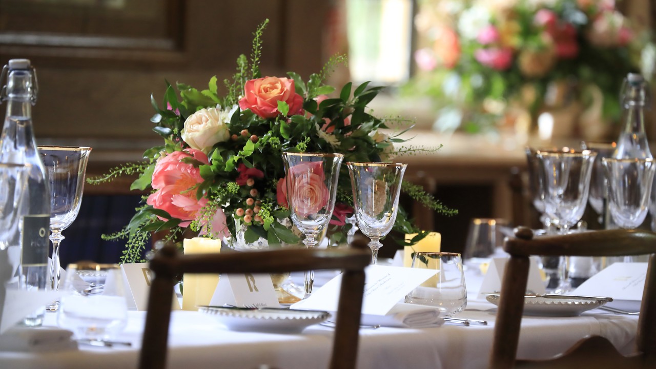 Pink flower arrangements on a dining table in the Beit Room.