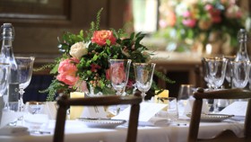 Pink flower arrangements on a dining table in the Beit Room.