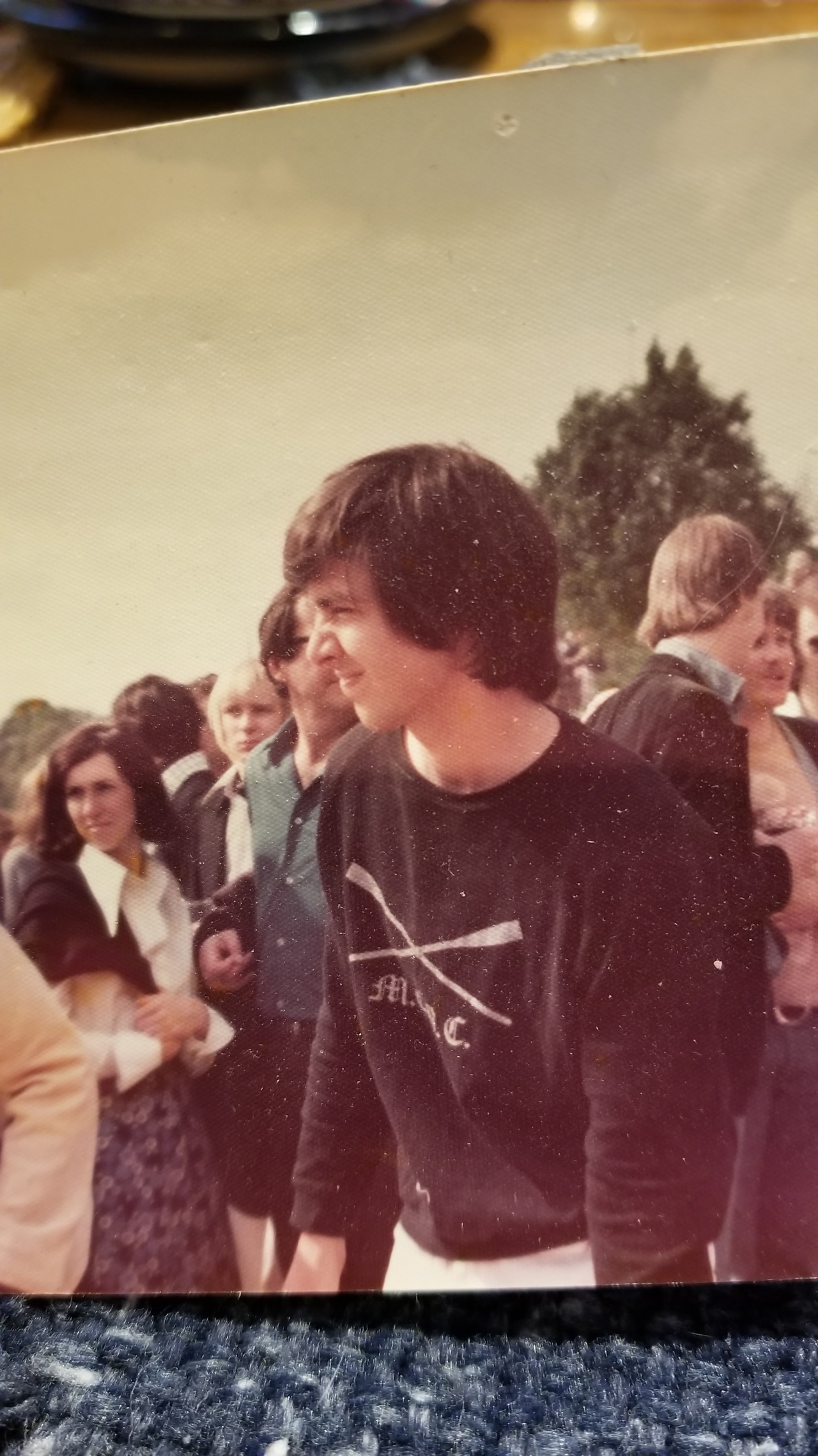 Image of Elliot wearing a sport sweatshirt in a crowd.