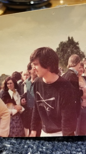 Image of Elliot wearing a sport sweatshirt in a crowd.
