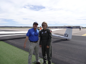 Michelle stood to the right of her husband, with a plane behind them.