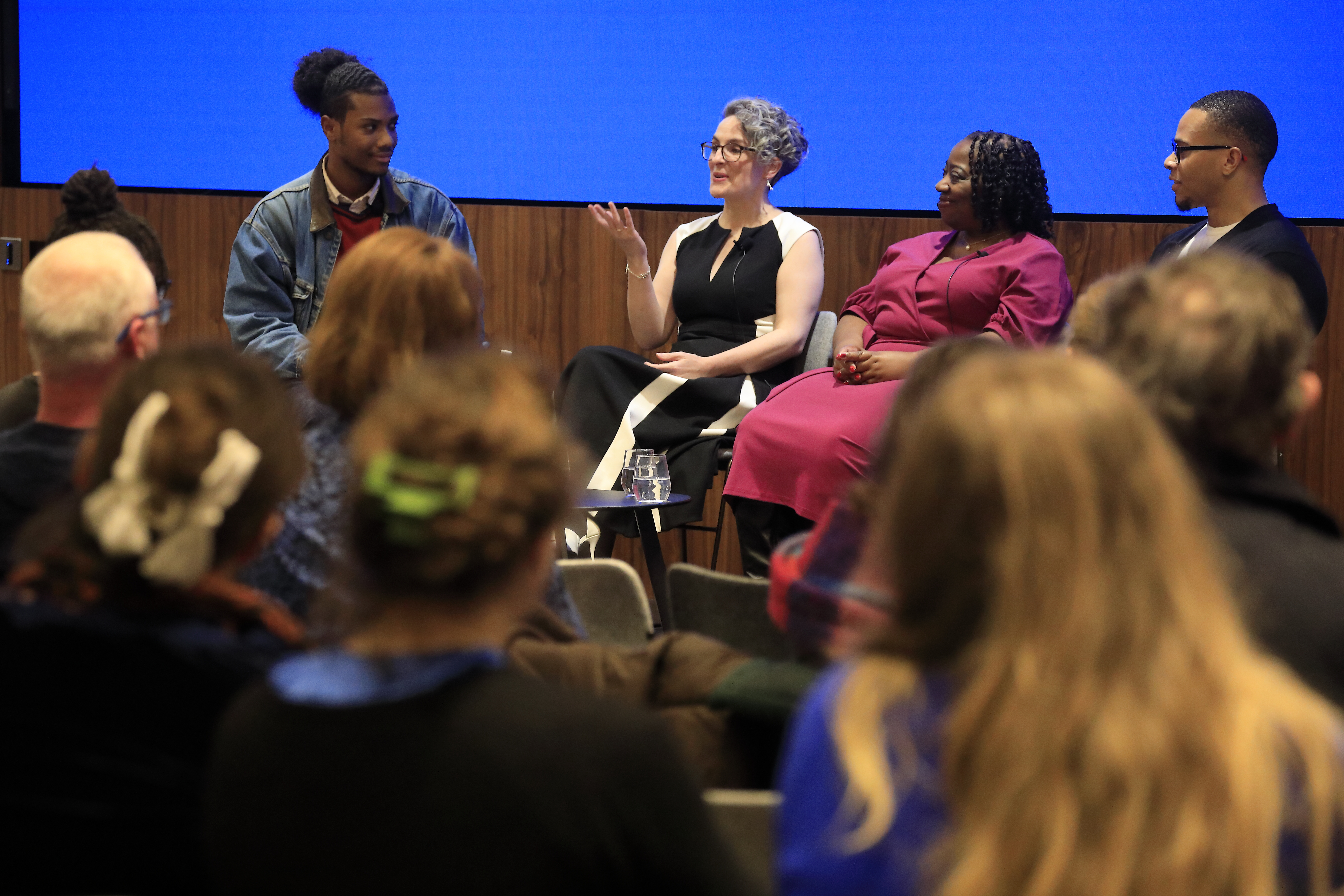 A close up of 4 panel members in conversation