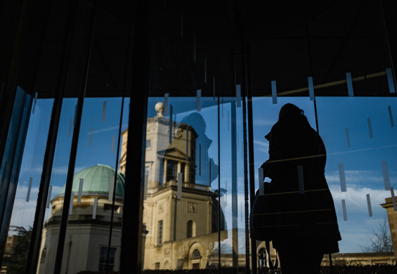 A Scholar in shadow in front of a plate glass window