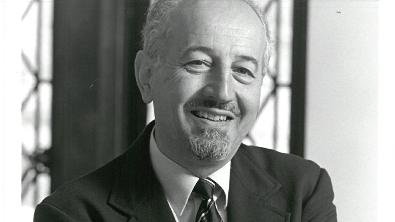 A black-and-white picture of Guido in a suit, with his arms crossed