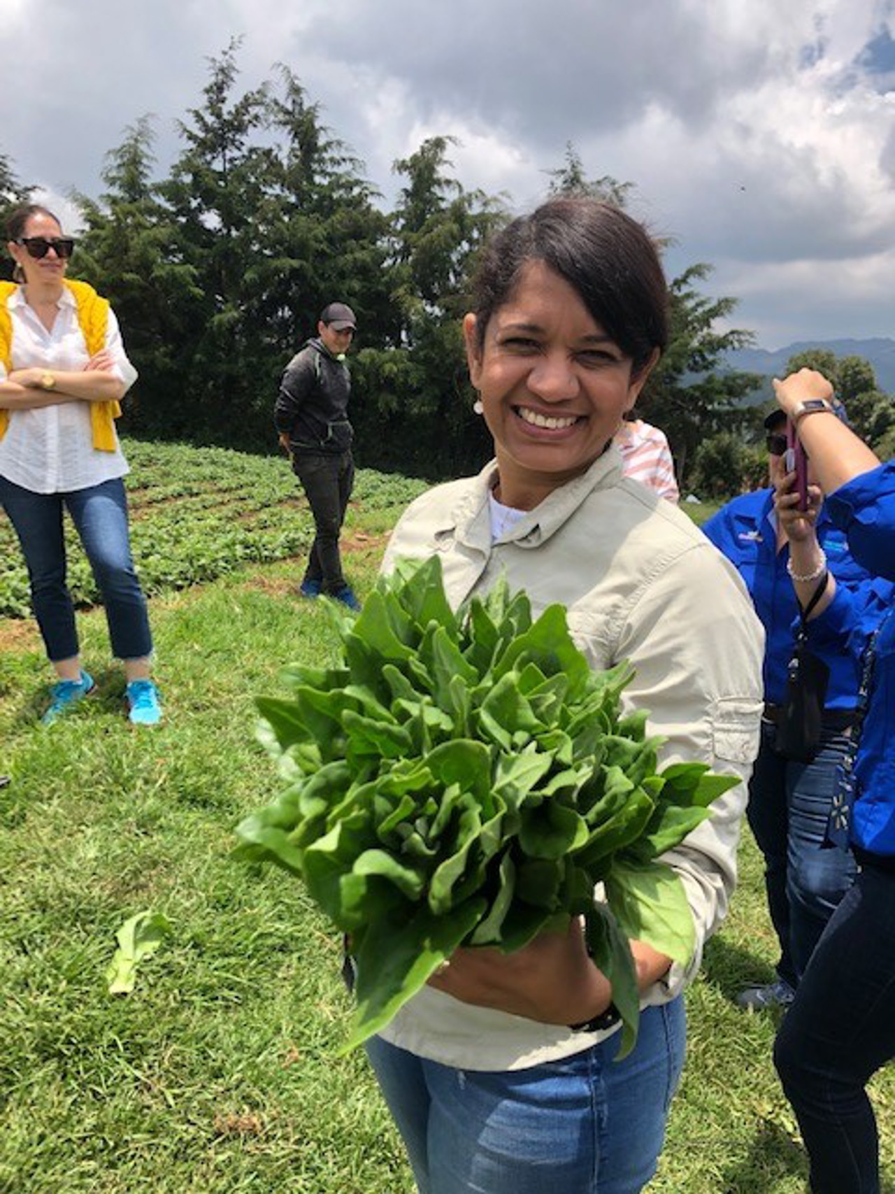 Sherry-Lee stood, smiling on a form holding green crops.