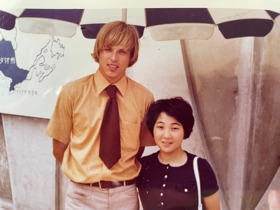 Sepia photo of Geza standing with a woman next to his right.