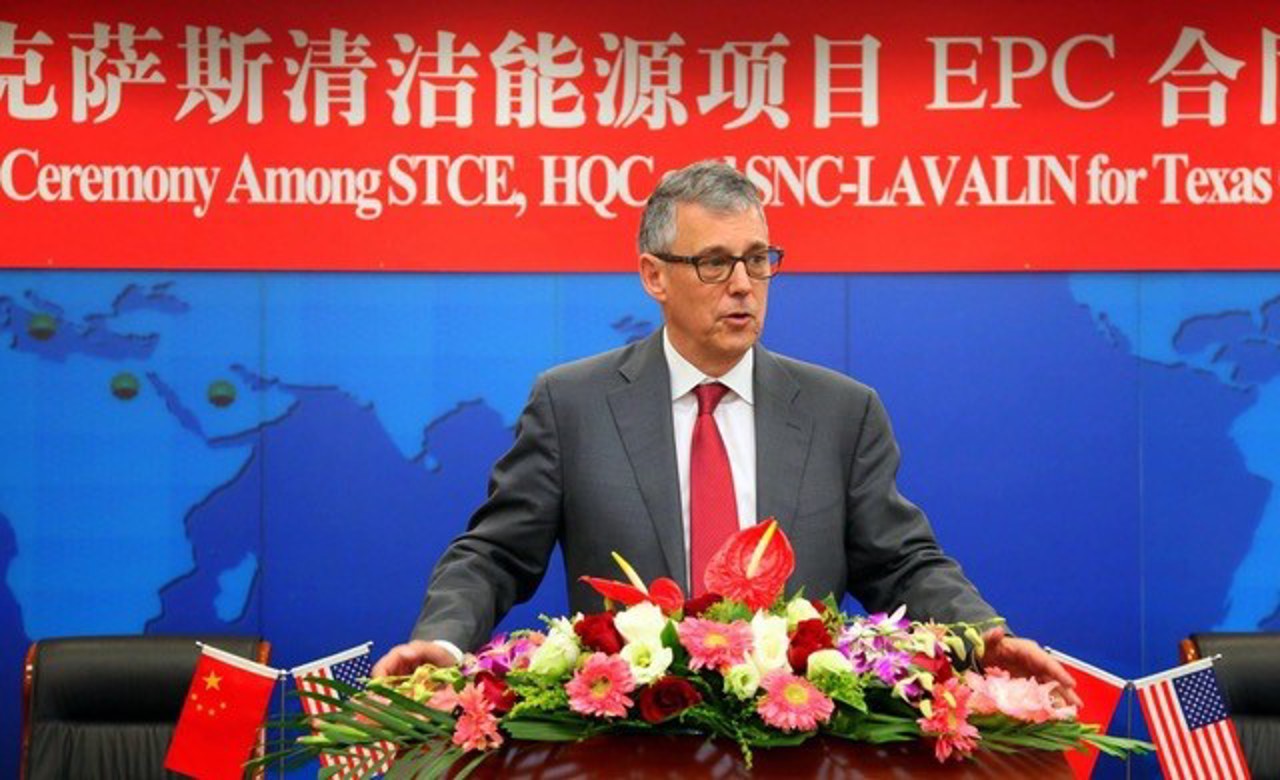 The picture shows Eric at a conference in China with flowers in front of the podium