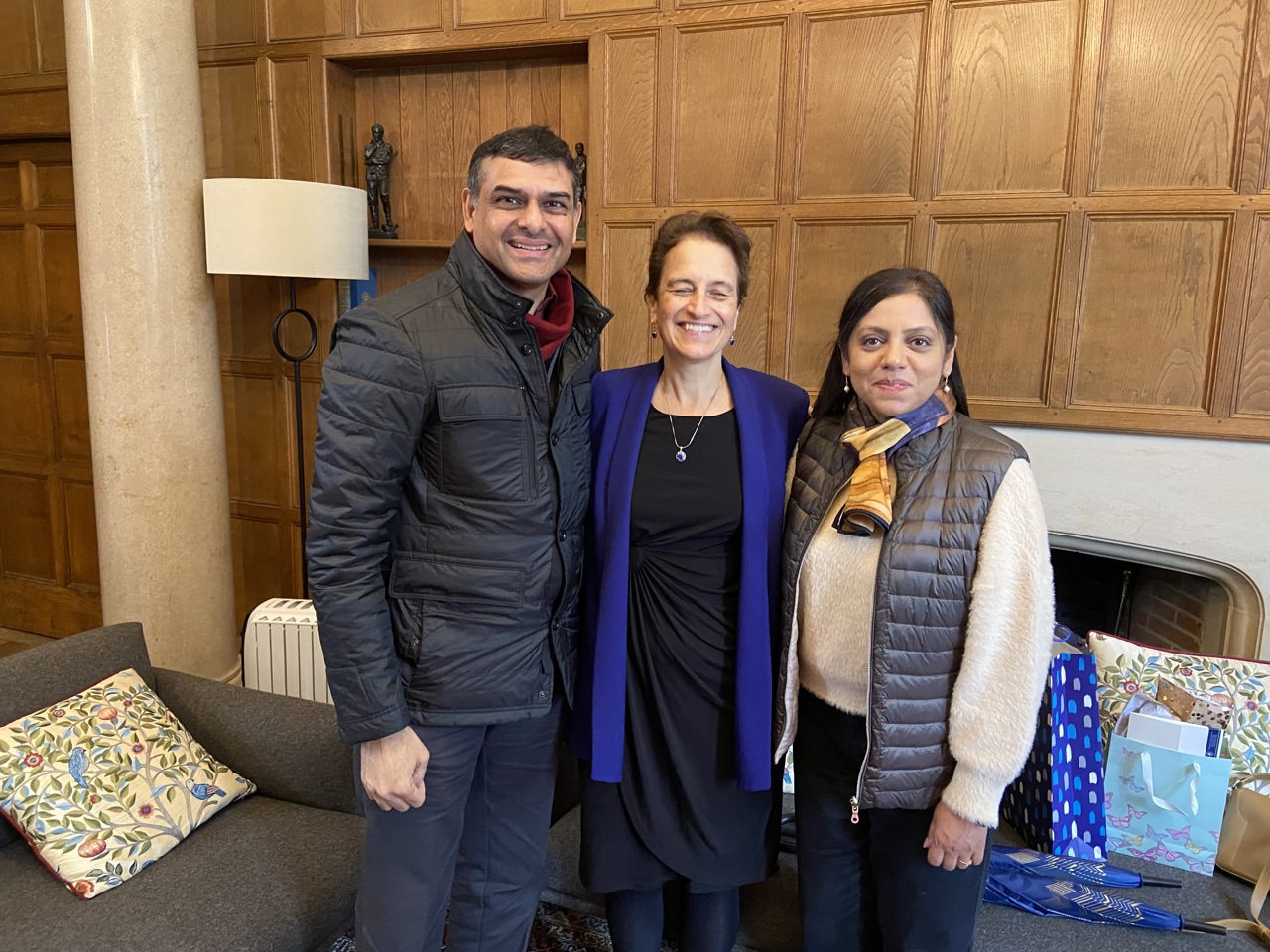 The picture shows Mukund and Soumya standing with Elizabeth Kiss in a wood-panelled room.