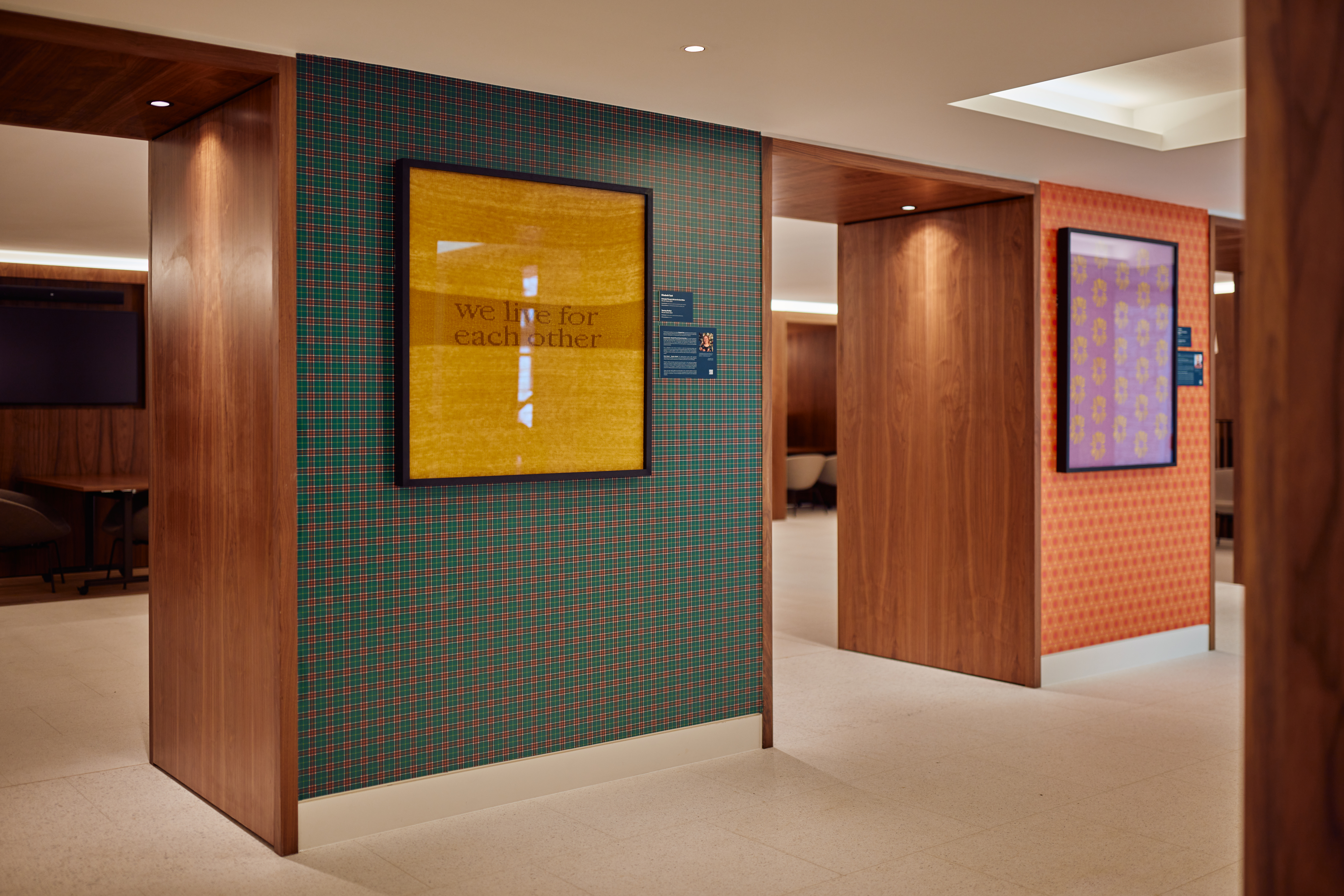 The art gallery at Rhodes House, featuring artwork framed on the wall which reads, "we live for each other".