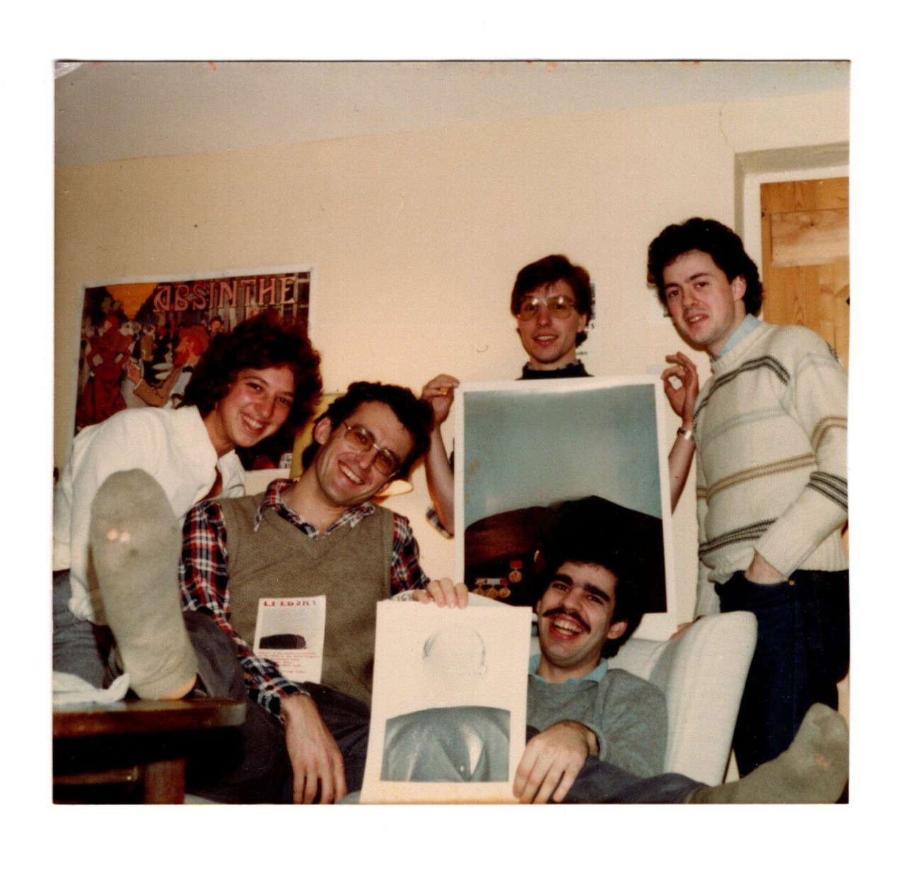 The picture shows a group of young students holding up drawings that they made