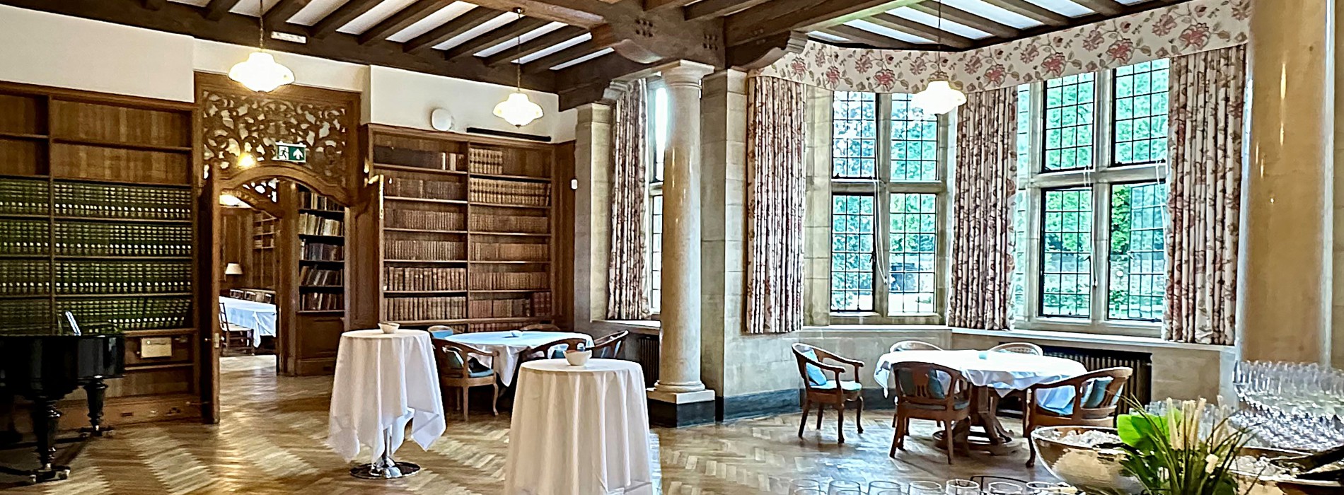 Reception Room set up for a drinks reception with two clothed poseur tables and a table with glasses in the foreground.