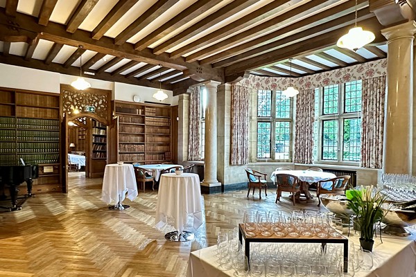 Reception Room set up for a drinks reception with two clothed poseur tables and a table with glasses in the foreground.