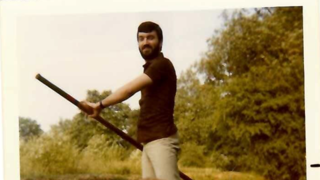 The picture shows a young Richard standing in a boat, punting. His mother is at the front of the boat.