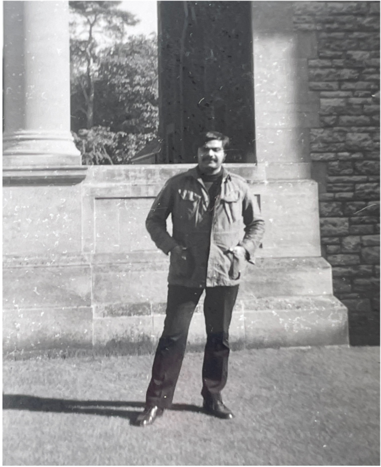 A black-and-white picture of Jahar with a massive sandstone pillar behind him