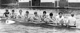 Black and white photo of group of students rowing, of whom Chris is one.