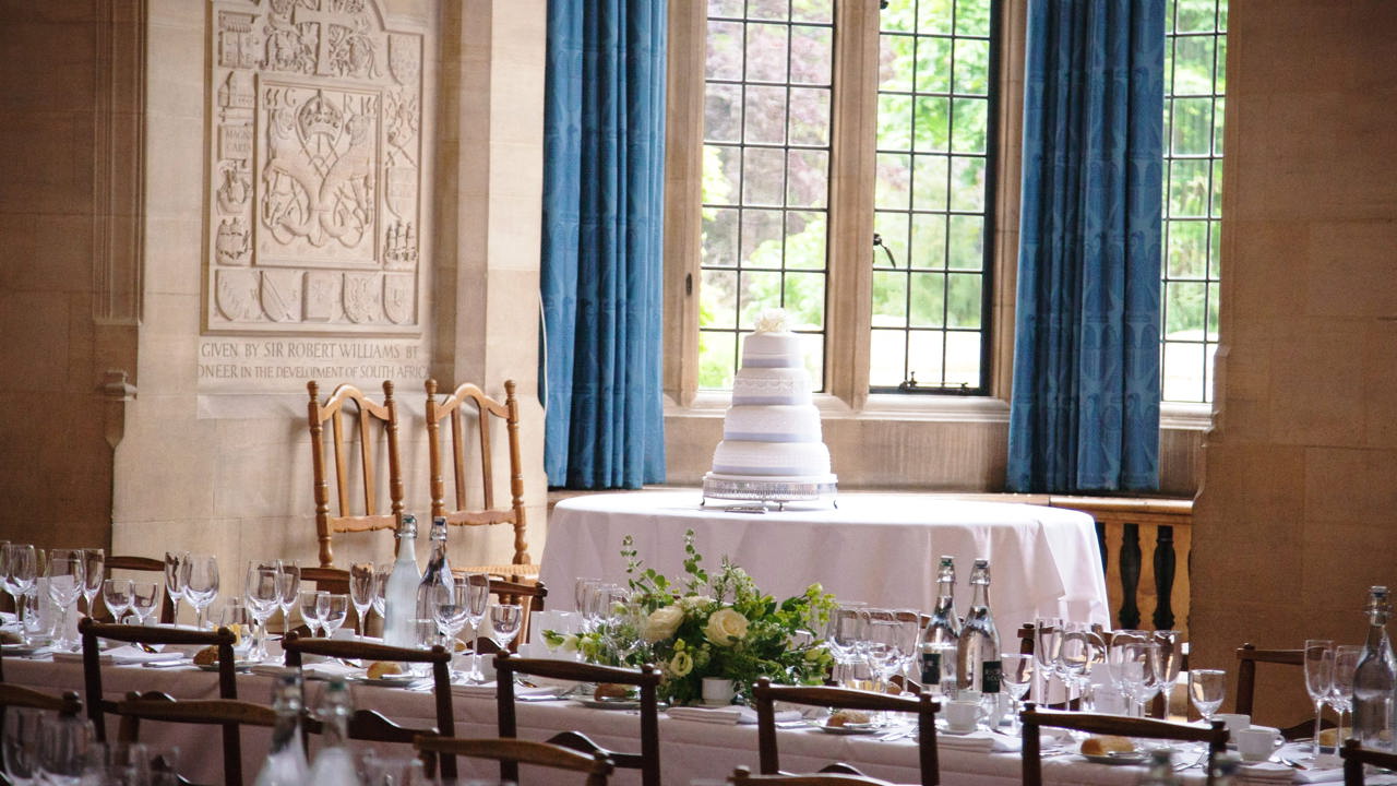 Wedding Cake On A Table In The McCall MacBain Hall Bay Window with wedding dinner tables in foreground.