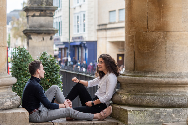 Students leaning on pillars and talking