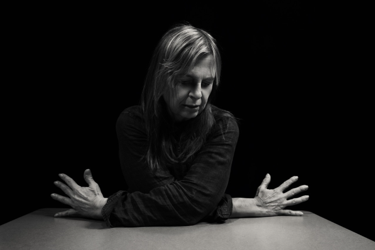 Black and white photo of Banuta with her hands splayed out to either side.