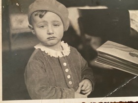 Black and white photo of Erich as a baby wearing a beret and looking grumpy.