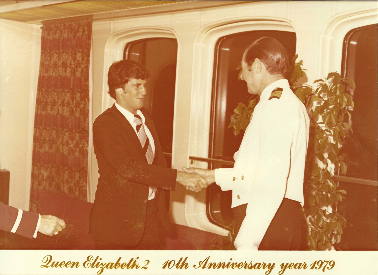 A sepia-tinted picture that shows John shaking hands with a ship captain