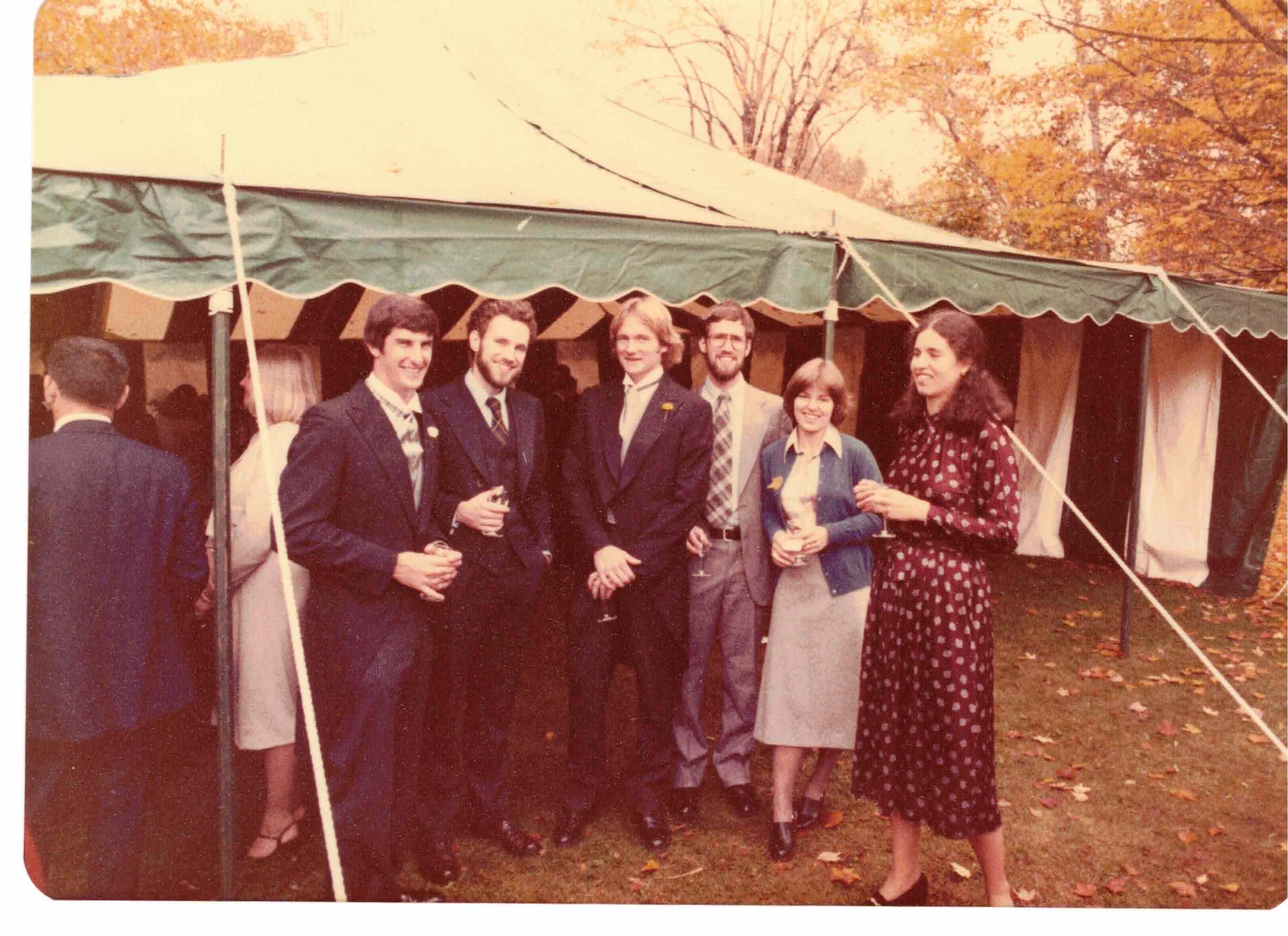Sepia tinted wedding photo of group standing before a gazebo.