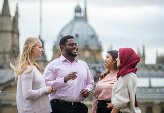 Four Scholars talking against a backdrop of the Oxford skyline