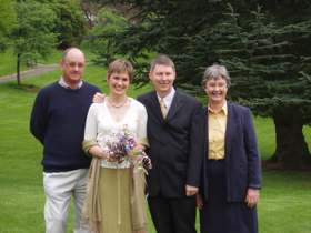 The picture shows Elle in a wedding dress along with her husband in a suit. Her parents stand on either side of the couple.