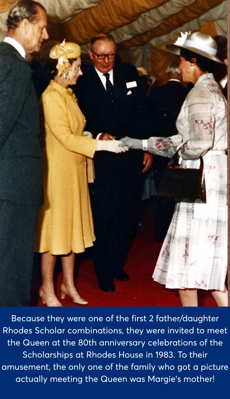 Margaret's mother wearing a white dress holding the Queen's hand, who is dressed in yellow. They are stood on a red carpet.