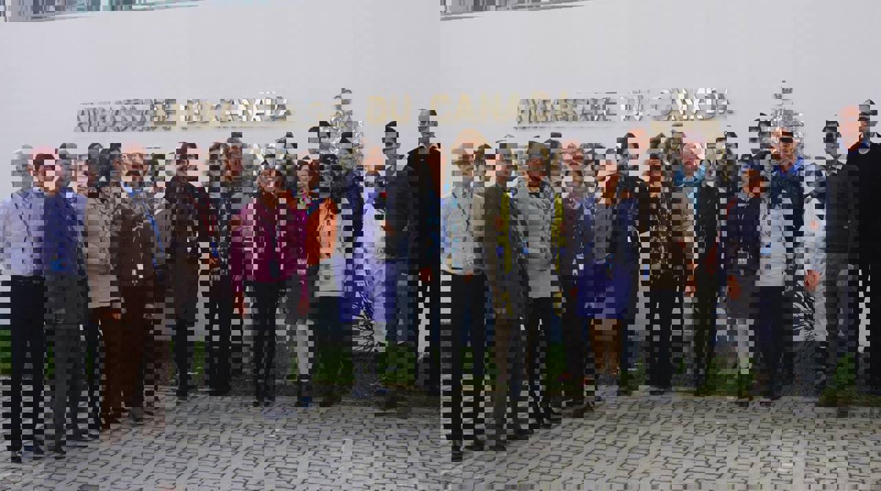 Carol stood with a large group of staff all dressed smart and smiling.