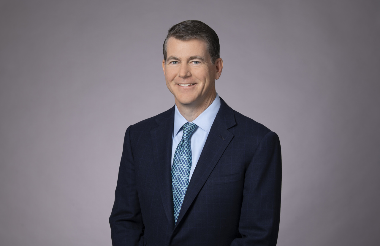 David in a suit stood smiling into the camera for a professional image.
