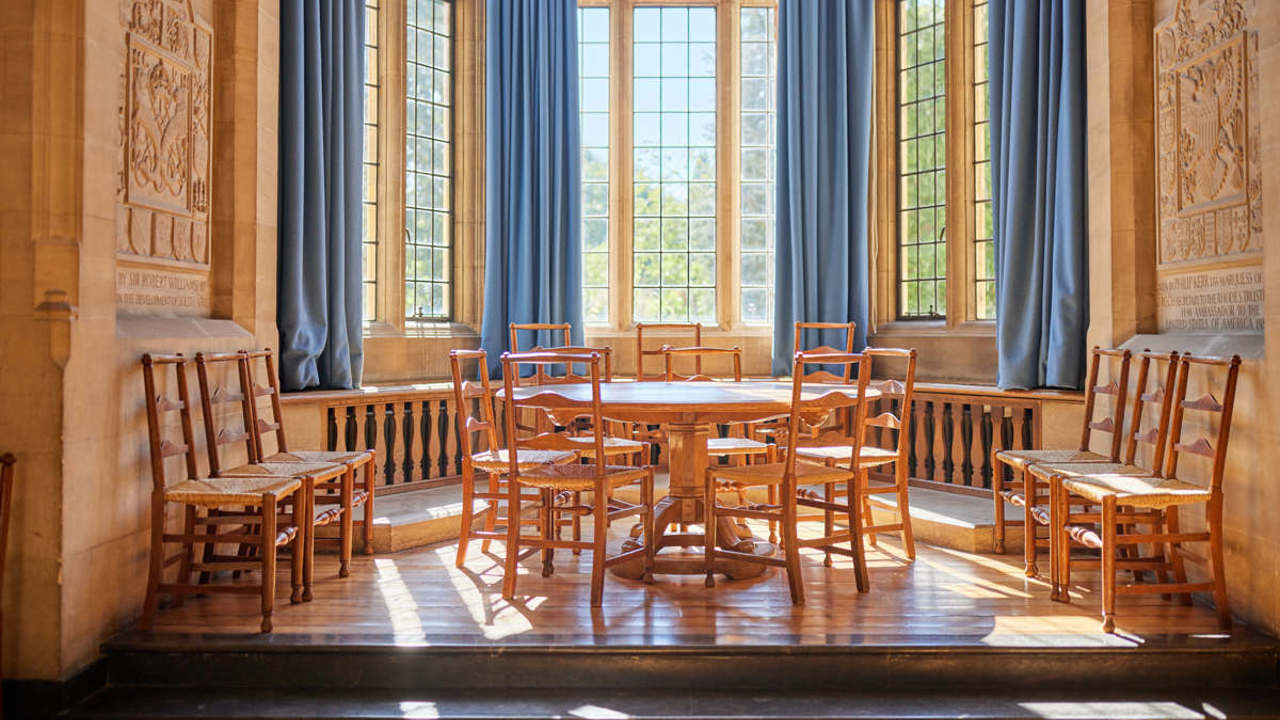Bay window in McCall MacBain Hall in the daytime, with round table and chairs.