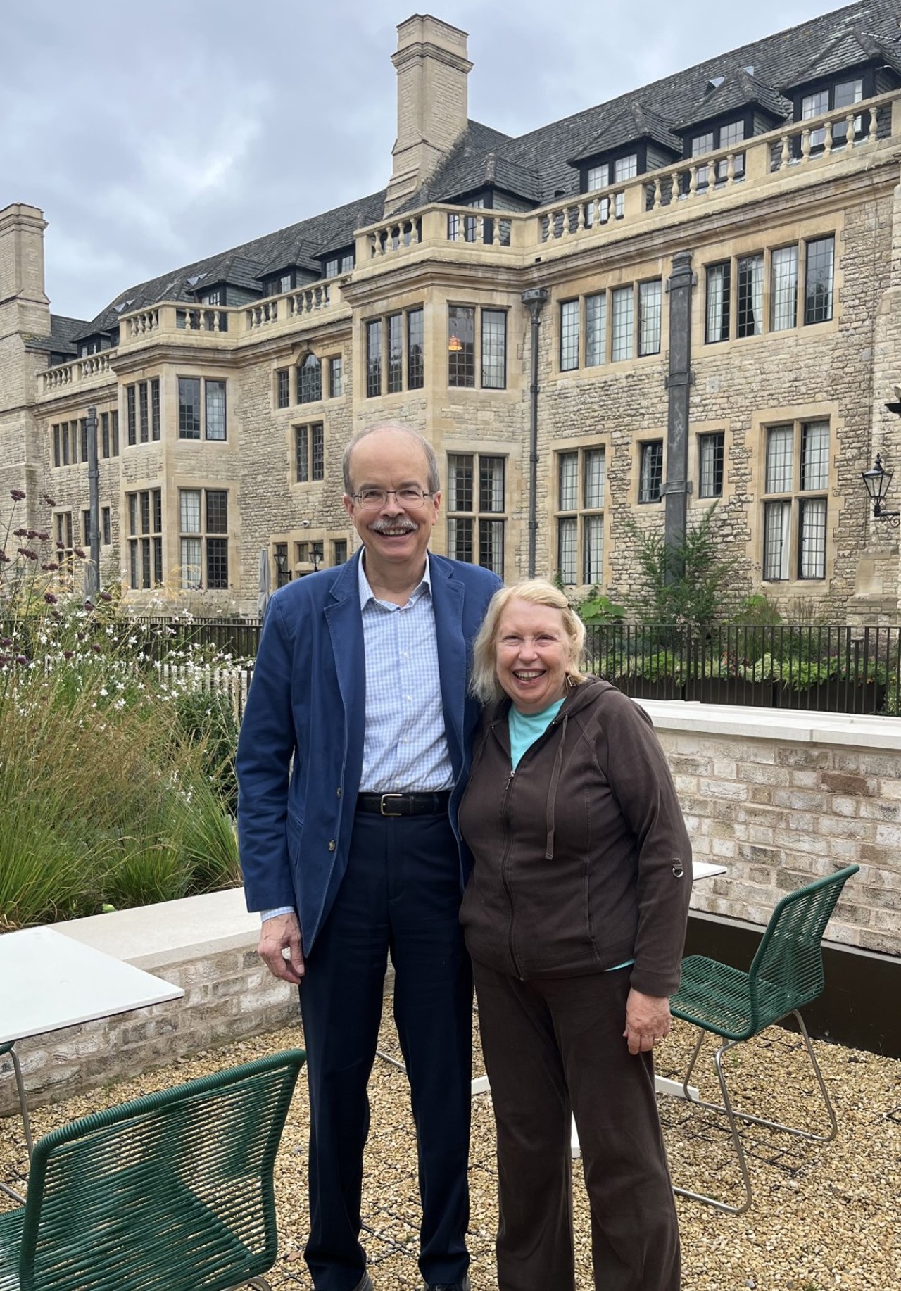 Couple standing smiling before Rhodes House.