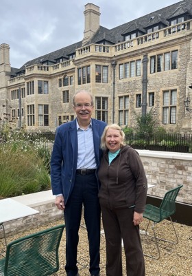 Couple standing smiling before Rhodes House.