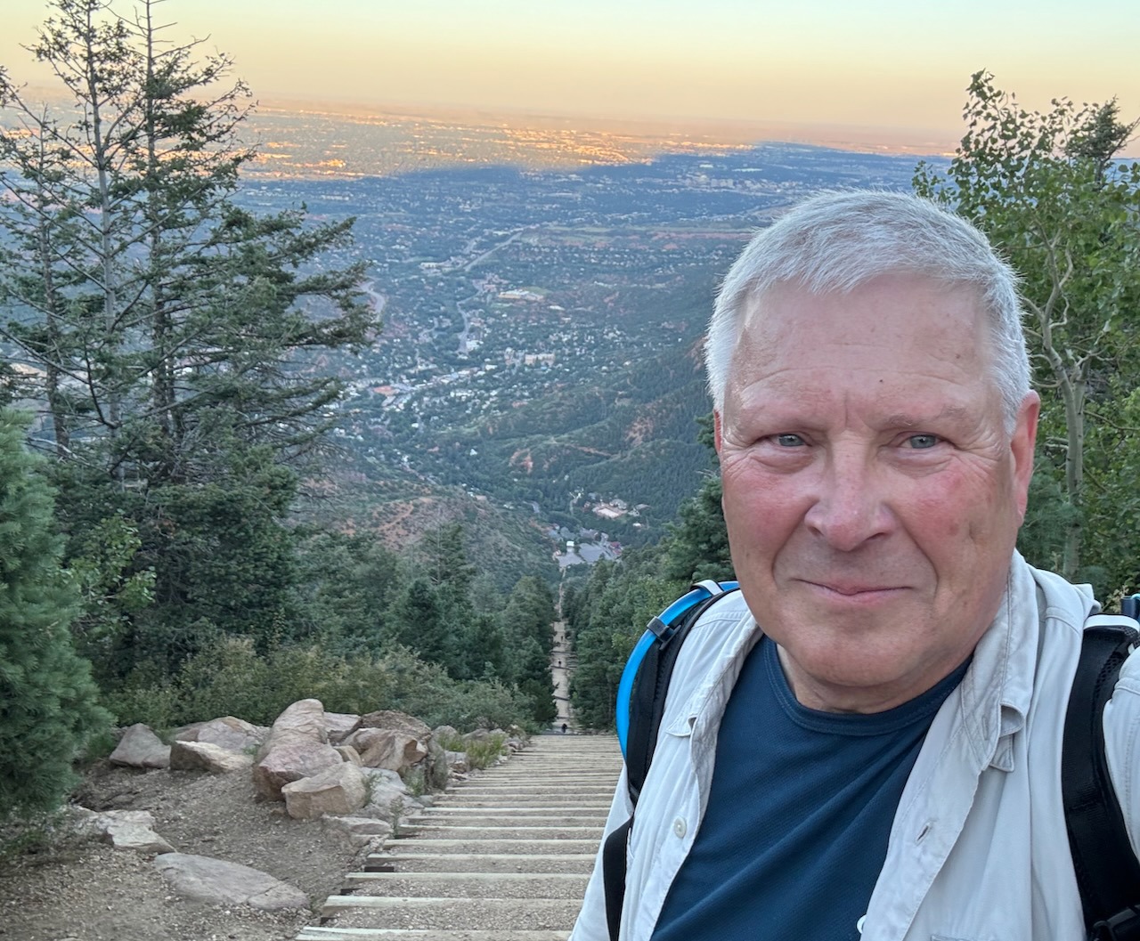 Selfie photo of Chris at the top of a hill with sunset in the background.