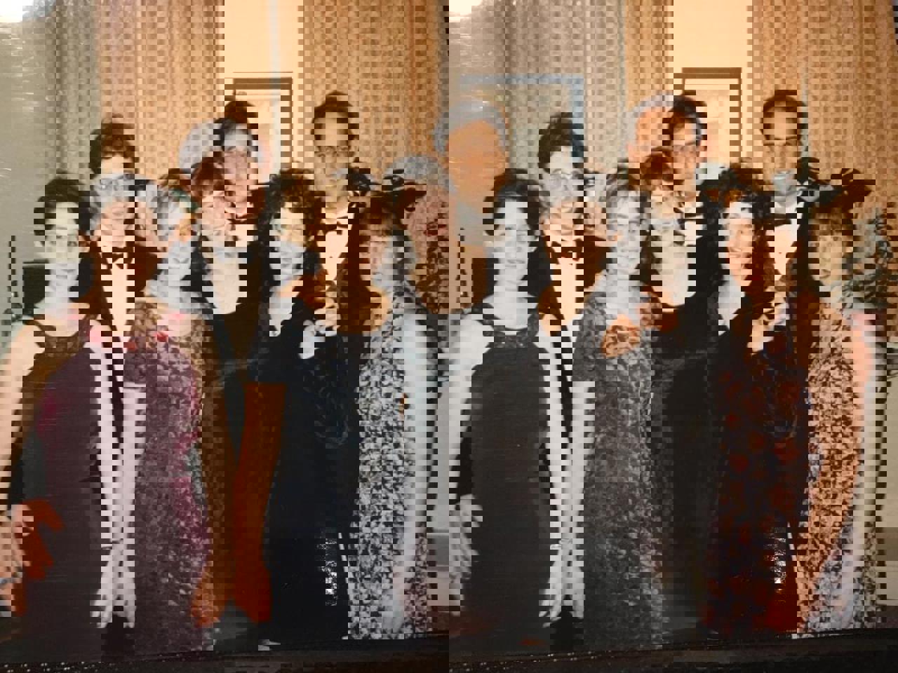 The picture shows a group of young students dressed in suits and dresses before a ball at Christ Church