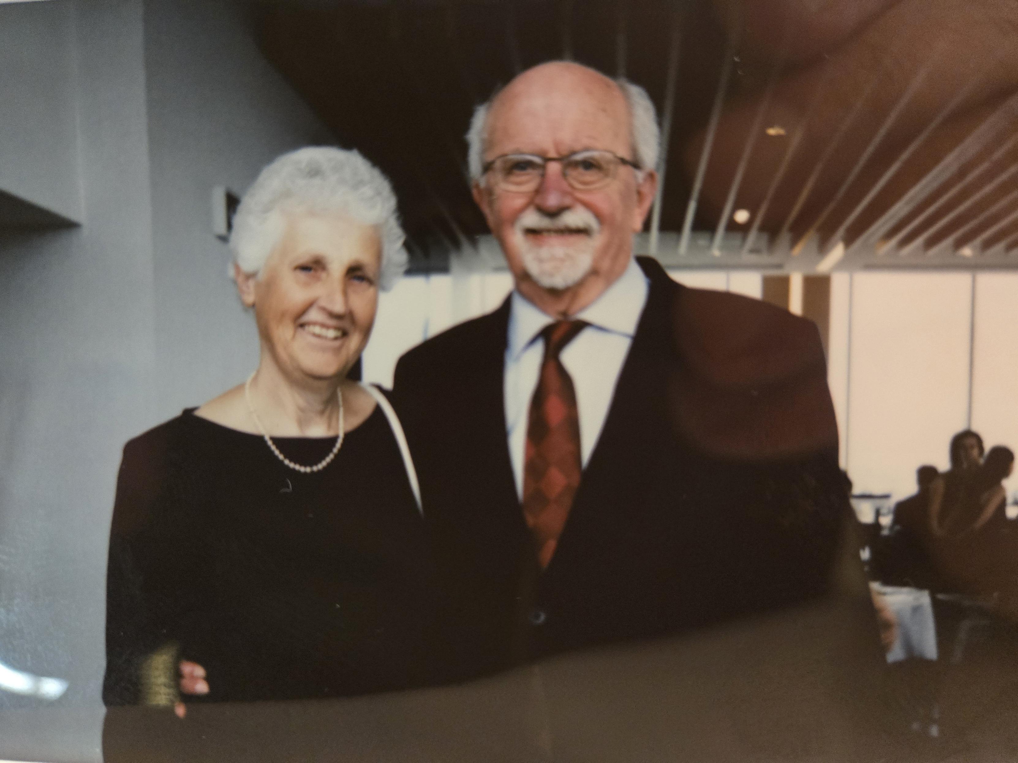 Andrew stood to the right in a black suit, with Christine to his left in a black dress. Both smiling.
