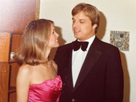 Photo of Geza as a young man wearing a black and white suit, with his wife Marcia wearing a pink dress beside him.