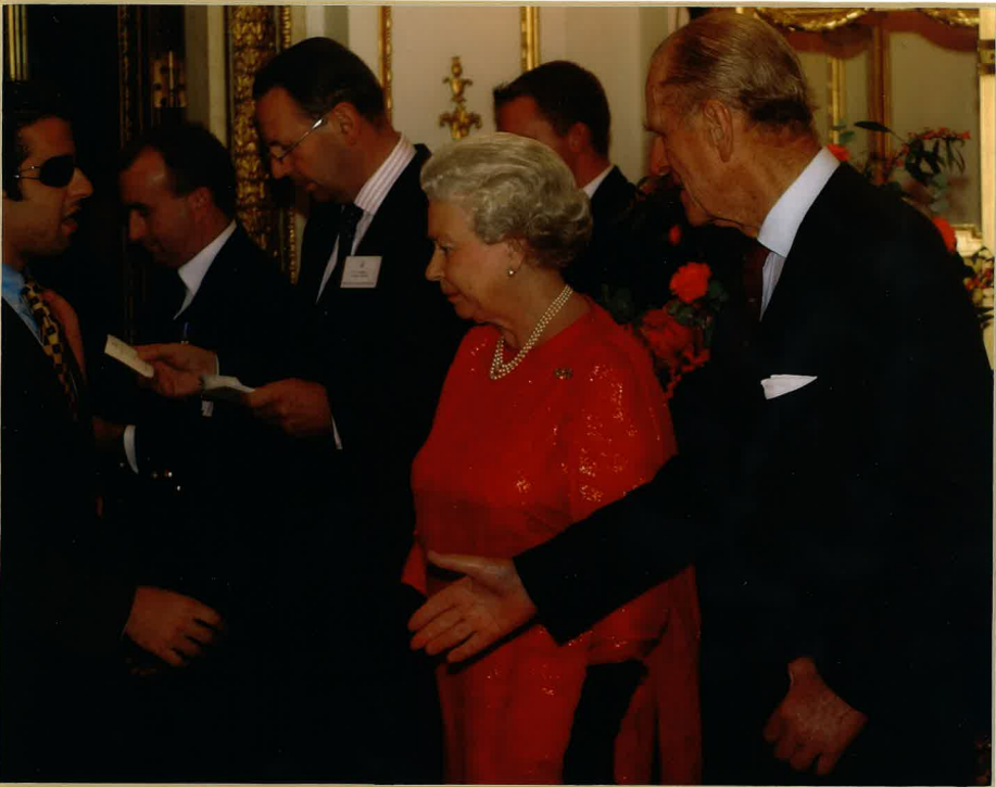 The photo shows Cyrus with Queen Elizabeth II and Prince Phillip, all in formal attire