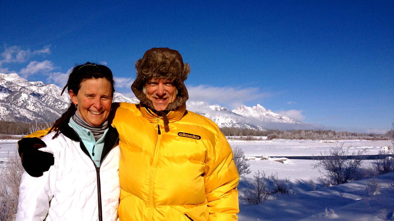 The picture shows Peter in a yellow puffer jacket with his arm around Elizabeth who is wearing a white jacket. Snowy environs around them.