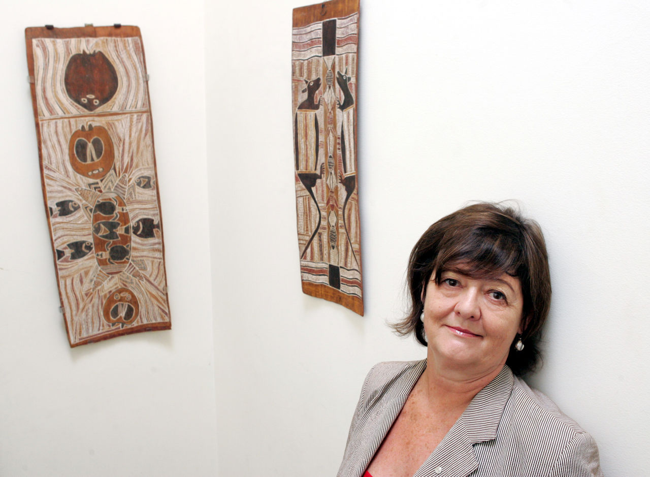 The picture shows Jaynie standing next to two specimens of indigenous art