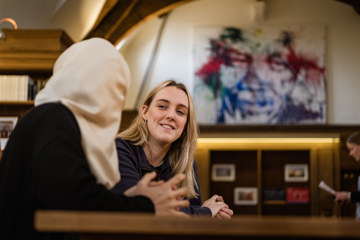 Scholars animatedly talking in the Rosebery room