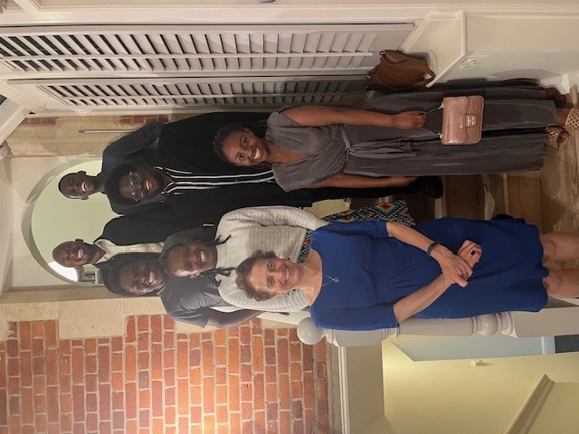 Elizabeth is stood at the front left with a group of 6 Scholars, all are dressed in formal clothes and smiling. They are standing on different steps, so are staggered to ensure that all fit in the shot.