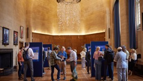Exhibition boards set up in McCall MacBain Hall with delegates mingling and viewing.