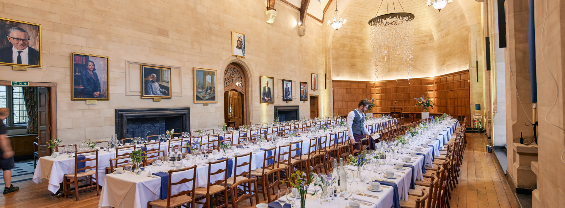 A Single Waiter Setting Places In McCall MacBain Hall for a private dinner.