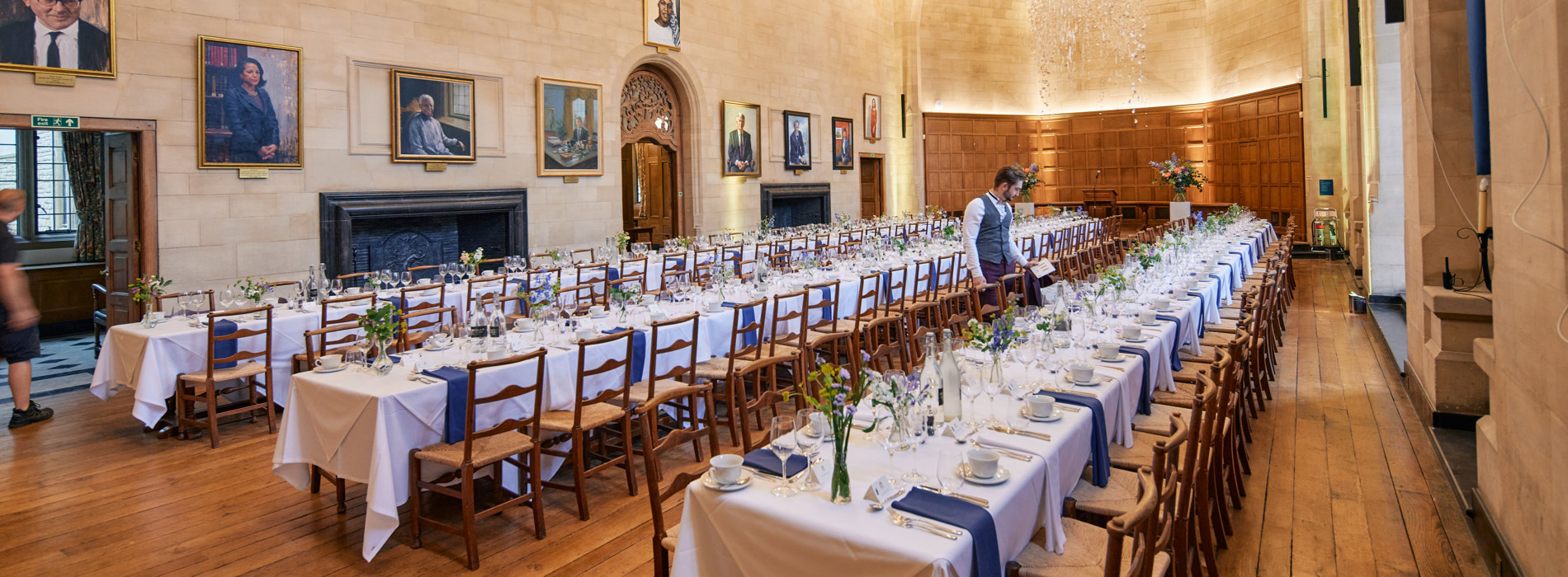 A Single Waiter Setting Places In McCall MacBain Hall for a private dinner.