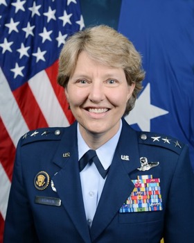 Michelle stood smiling before the American flag, wearing uniform adorned in medals.
