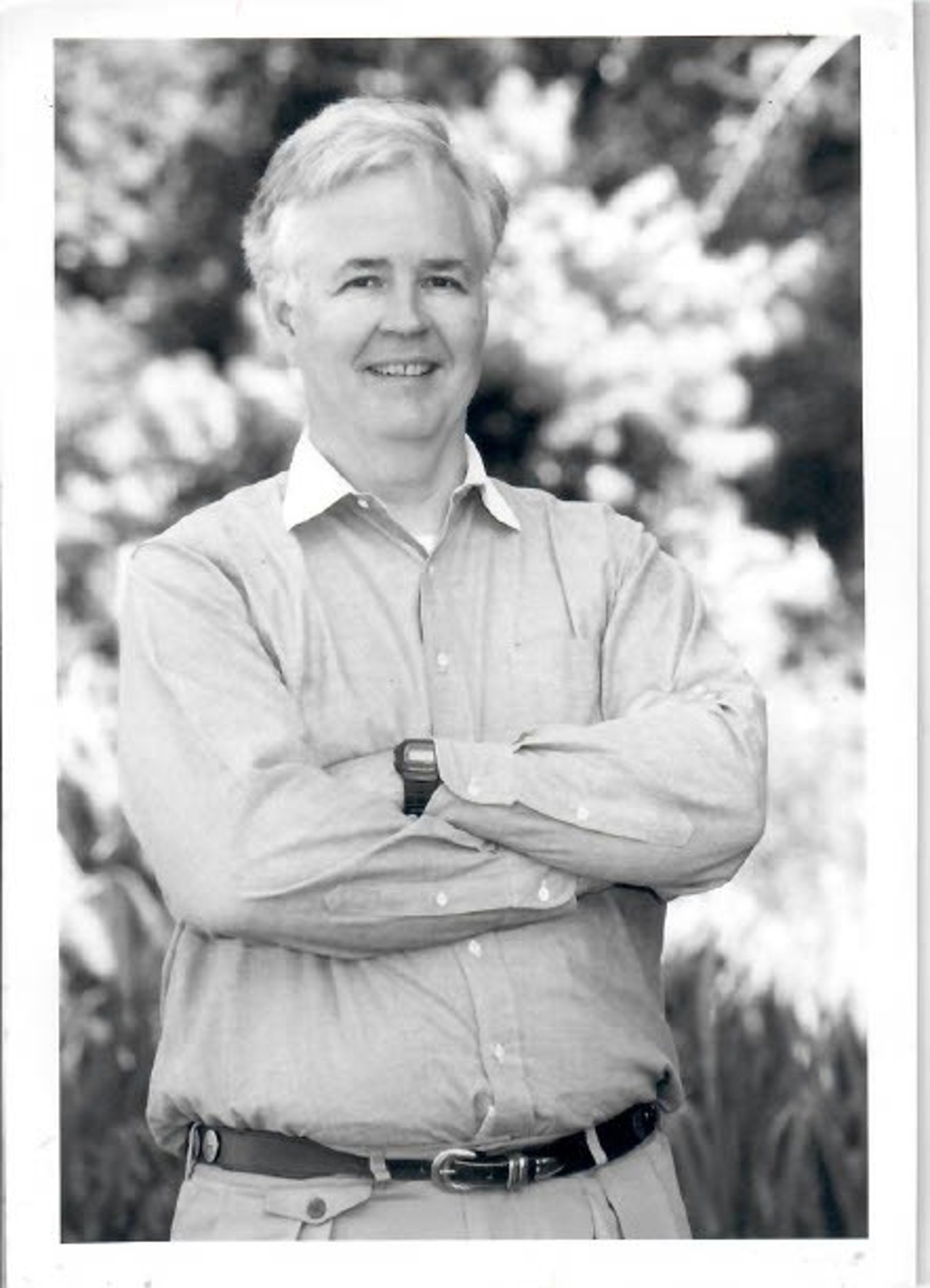 A black-and-white picture of an older Norton. He's standing with his arms crossed.
