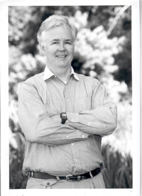 A black-and-white picture of an older Norton. He's standing with his arms crossed.