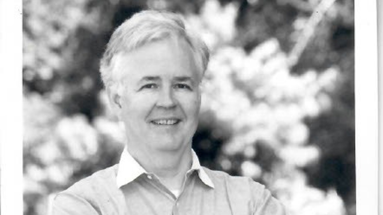 A black-and-white picture of an older Norton. He's standing with his arms crossed.